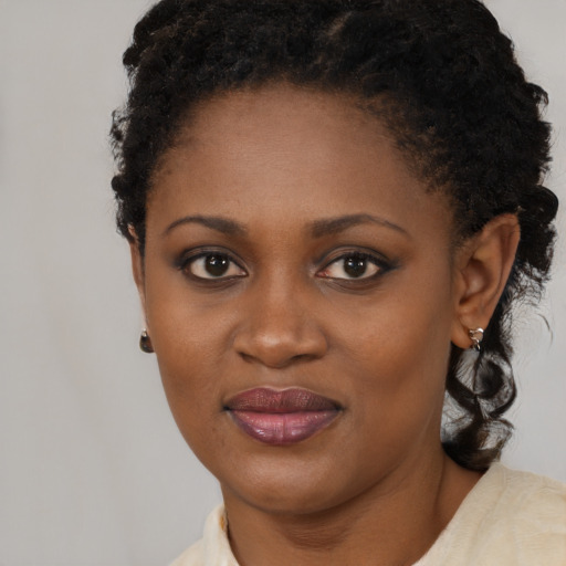 Joyful black young-adult female with short  brown hair and brown eyes