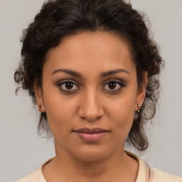 Joyful latino young-adult female with medium  brown hair and brown eyes