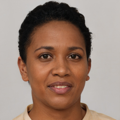 Joyful black young-adult female with short  brown hair and brown eyes