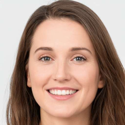 Joyful white young-adult female with long  brown hair and grey eyes