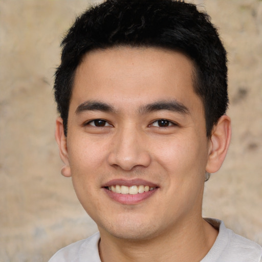 Joyful asian young-adult male with short  black hair and brown eyes