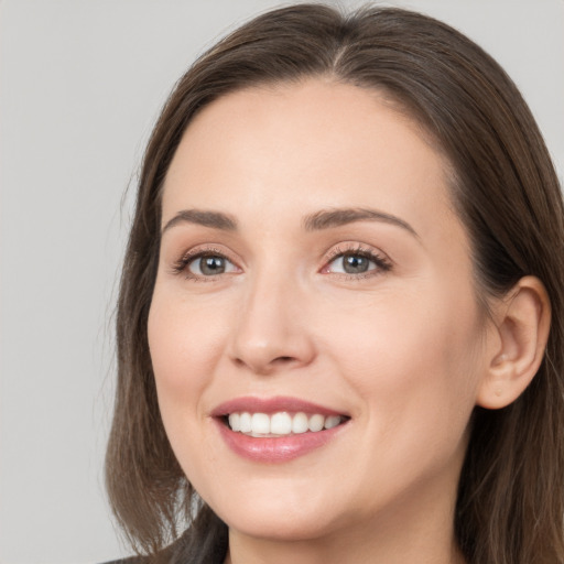 Joyful white young-adult female with long  brown hair and brown eyes