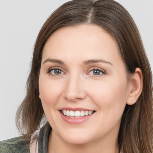 Joyful white young-adult female with medium  brown hair and grey eyes