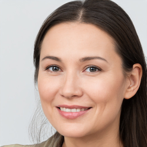 Joyful white young-adult female with long  brown hair and brown eyes