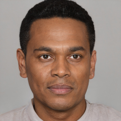 Joyful black young-adult male with short  black hair and brown eyes