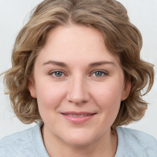 Joyful white young-adult female with medium  brown hair and blue eyes