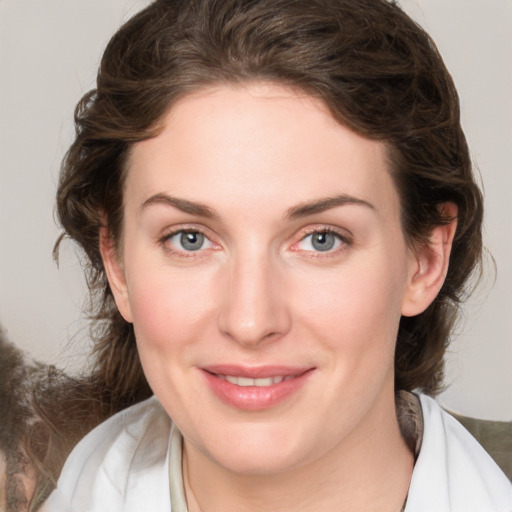 Joyful white young-adult female with medium  brown hair and green eyes