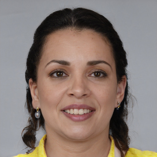 Joyful latino adult female with medium  brown hair and brown eyes