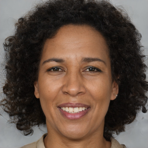 Joyful black adult female with medium  brown hair and brown eyes