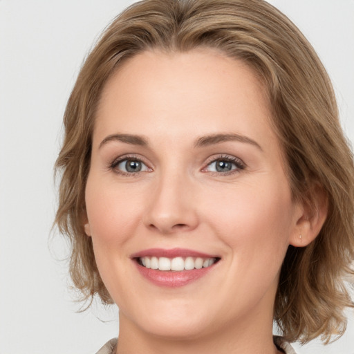 Joyful white young-adult female with medium  brown hair and blue eyes