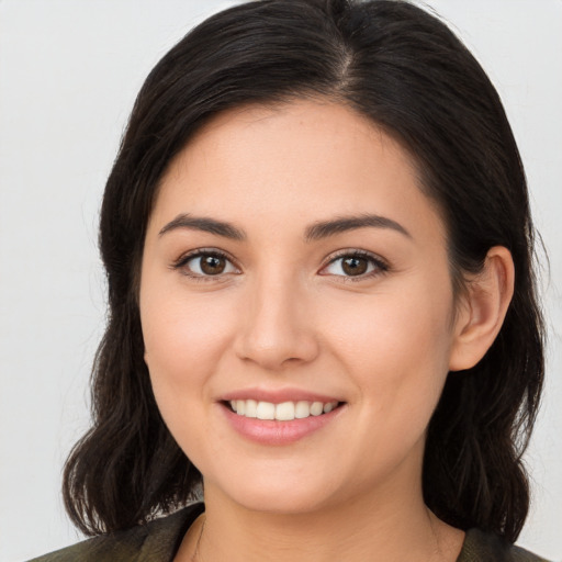 Joyful white young-adult female with long  brown hair and brown eyes