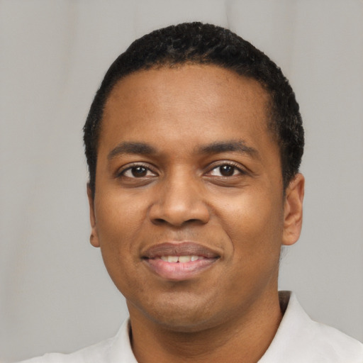 Joyful black young-adult male with short  black hair and brown eyes