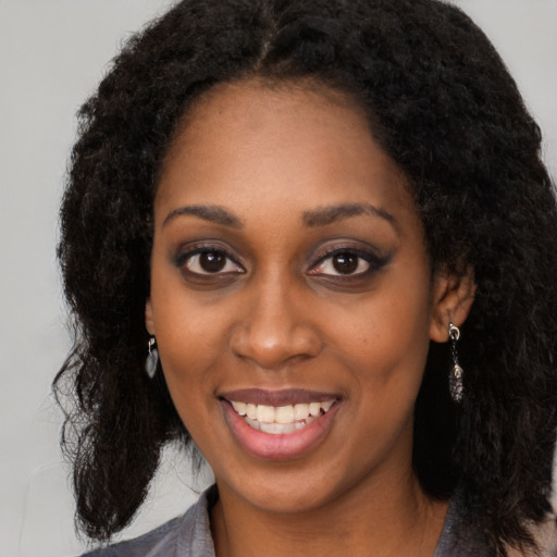 Joyful black young-adult female with long  black hair and brown eyes