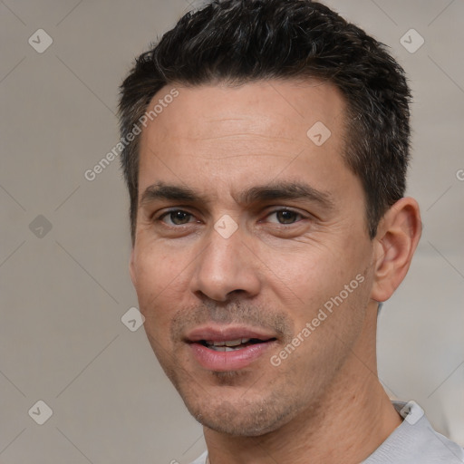 Joyful white adult male with short  black hair and brown eyes