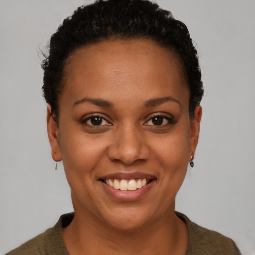Joyful black young-adult female with short  brown hair and brown eyes