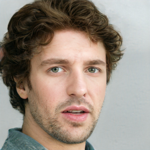 Joyful white young-adult male with short  brown hair and blue eyes