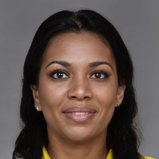 Joyful black young-adult female with long  brown hair and brown eyes