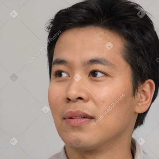 Joyful asian young-adult male with short  black hair and brown eyes