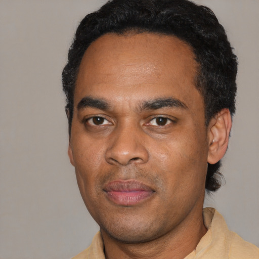 Joyful black young-adult male with short  black hair and brown eyes
