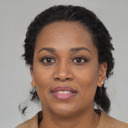 Joyful black adult female with medium  brown hair and brown eyes