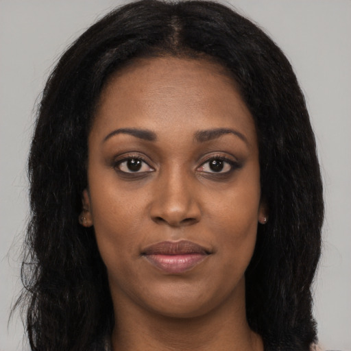 Joyful black young-adult female with long  brown hair and brown eyes