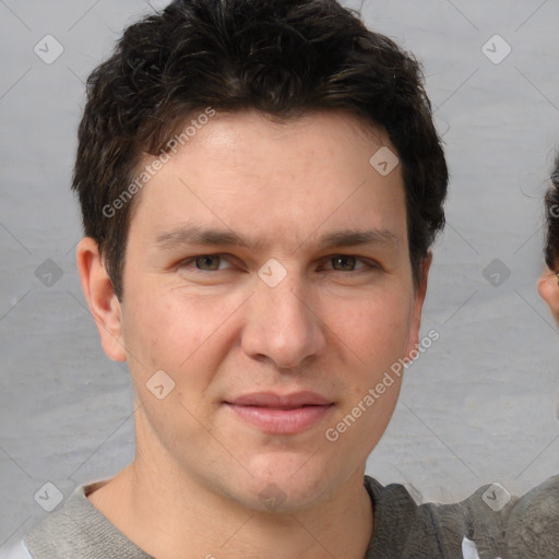 Joyful white young-adult male with short  brown hair and grey eyes