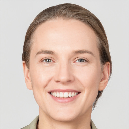 Joyful white young-adult female with short  brown hair and grey eyes