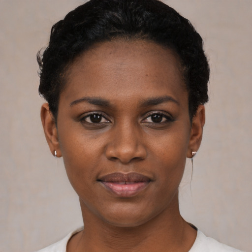 Joyful black young-adult female with short  black hair and brown eyes