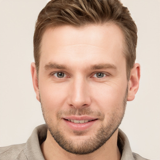 Joyful white young-adult male with short  brown hair and grey eyes