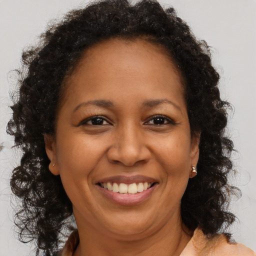 Joyful black adult female with long  brown hair and brown eyes