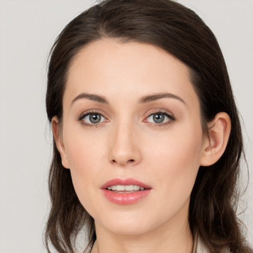 Joyful white young-adult female with long  brown hair and brown eyes