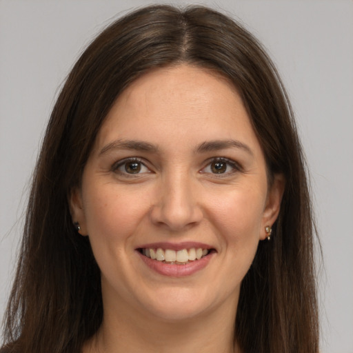 Joyful white young-adult female with long  brown hair and brown eyes