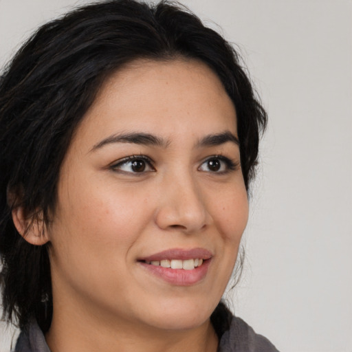 Joyful latino young-adult female with medium  brown hair and brown eyes