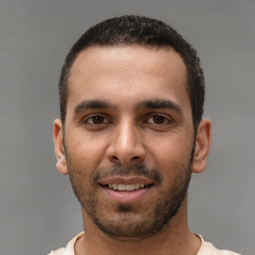 Joyful white young-adult male with short  black hair and brown eyes