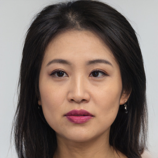 Joyful asian young-adult female with long  brown hair and brown eyes