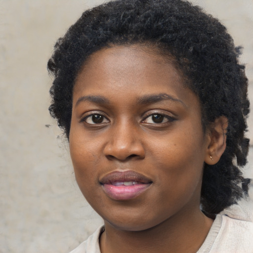 Joyful black young-adult female with short  black hair and brown eyes