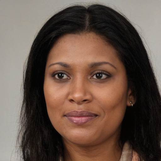 Joyful black young-adult female with long  brown hair and brown eyes