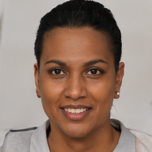 Joyful black young-adult female with short  black hair and brown eyes