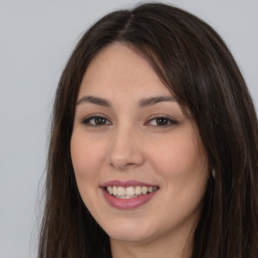 Joyful white young-adult female with long  brown hair and brown eyes