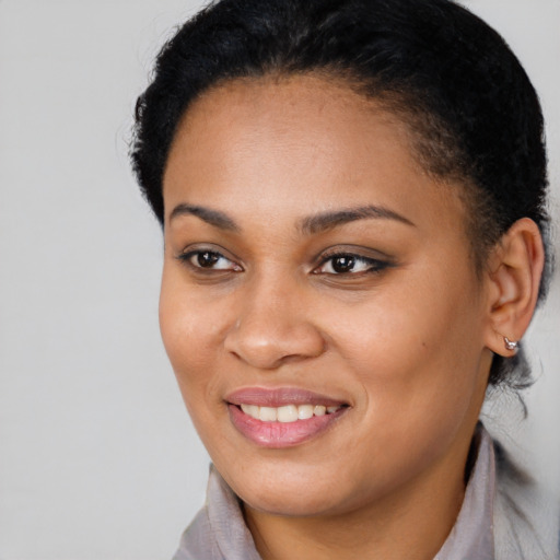 Joyful black young-adult female with short  black hair and brown eyes