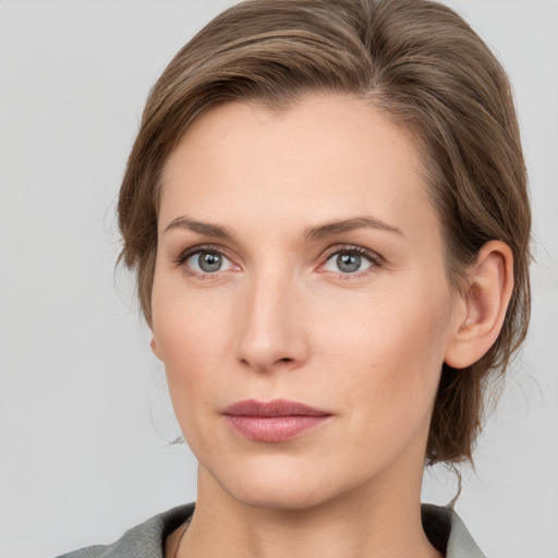 Joyful white young-adult female with medium  brown hair and grey eyes