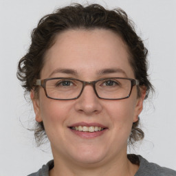 Joyful white adult female with medium  brown hair and grey eyes