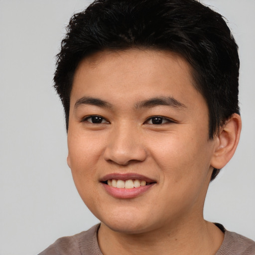 Joyful asian young-adult male with short  brown hair and brown eyes