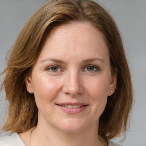 Joyful white young-adult female with medium  brown hair and blue eyes