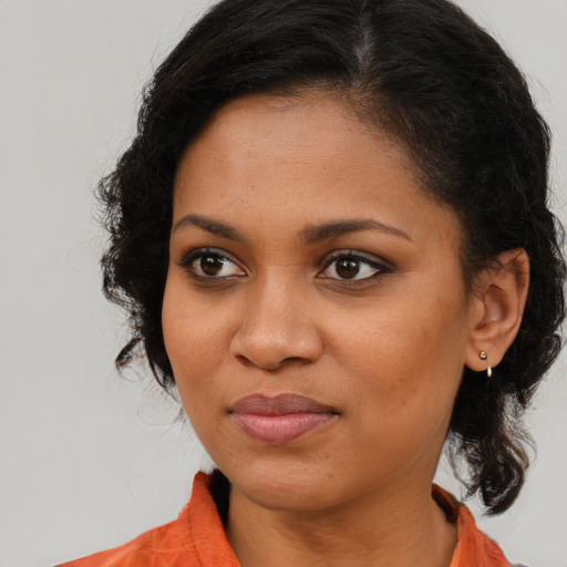 Joyful black young-adult female with long  brown hair and brown eyes