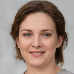 Joyful white young-adult female with medium  brown hair and green eyes