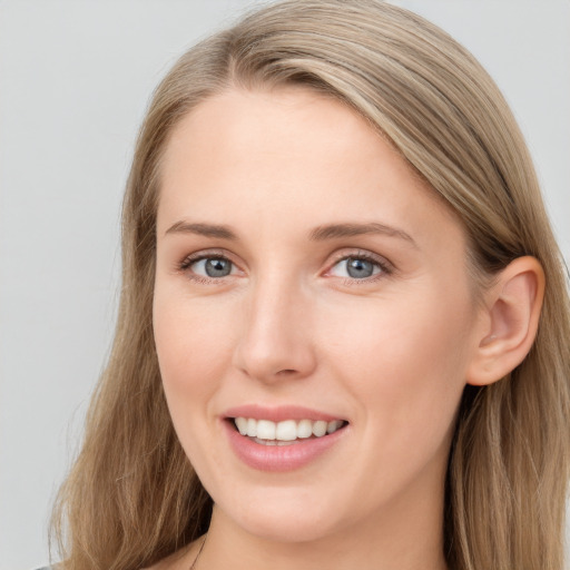 Joyful white young-adult female with long  brown hair and blue eyes