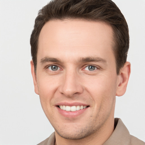 Joyful white young-adult male with short  brown hair and grey eyes