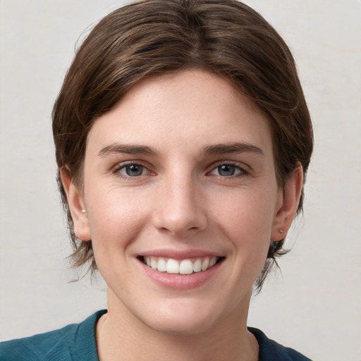 Joyful white young-adult female with medium  brown hair and grey eyes