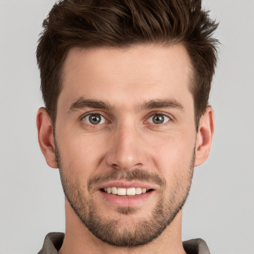 Joyful white young-adult male with short  brown hair and grey eyes